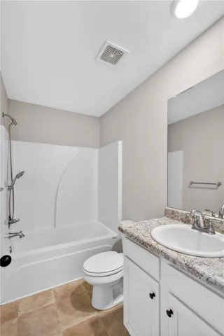A well-appointed bathroom offers a clean vanity with ample counter space and a classic tub/shower combination.