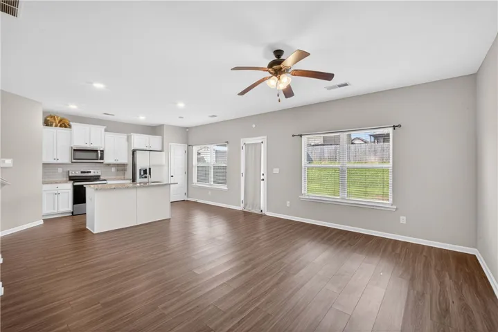 An open concept living area seamlessly flows into a well-appointed kitchen, ideal for daily living and entertaining.