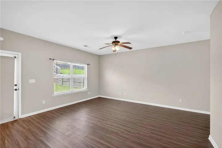 Rich wood flooring and a refreshing ceiling fan complement this adaptable room.