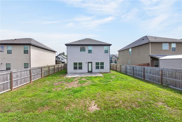 A spacious backyard enclosed by a wooden fence, offering ample room for outdoor activities.