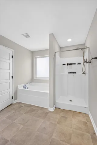 A well-appointed bathroom offers a separate soaking tub and walk-in shower for ultimate comfort.