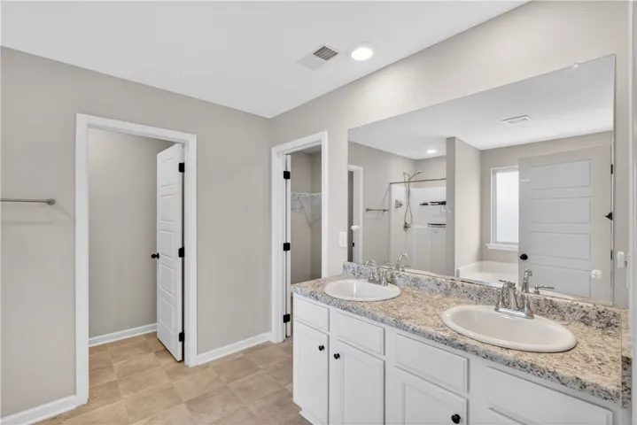 A sleek vanity with dual sinks, set against a pristine wall, promises a serene start to every day.