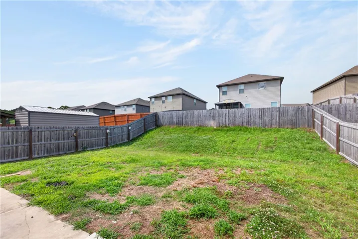 A spacious backyard with mature fencing offers privacy and a canvas for outdoor aspirations.