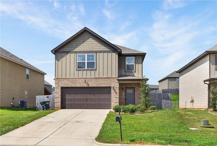 A welcoming facade showcases mixed materials, an attached garage, and a neatly landscaped front yard.