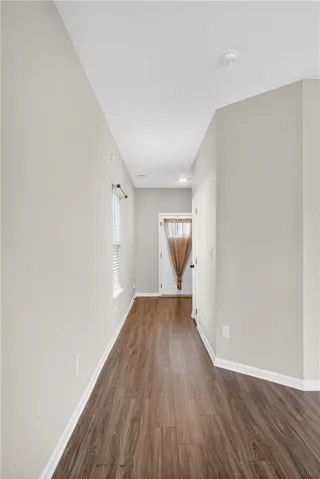 Enter a welcoming hallway featuring resilient wood-look flooring and a sun-filled window.