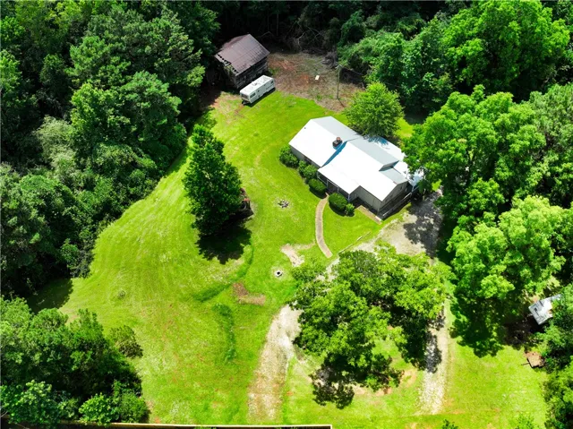An aerial perspective reveals a secluded estate nestled within a vibrant green landscape.