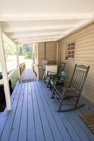 Relax on the inviting porch, a peaceful retreat with a sturdy railing and ample space for comfortable seating.