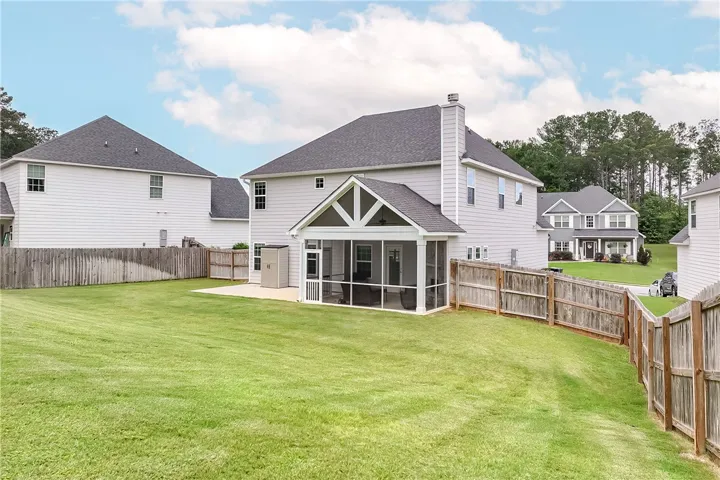 A spacious backyard with a private screened porch and fenced perimeter for relaxed outdoor living.