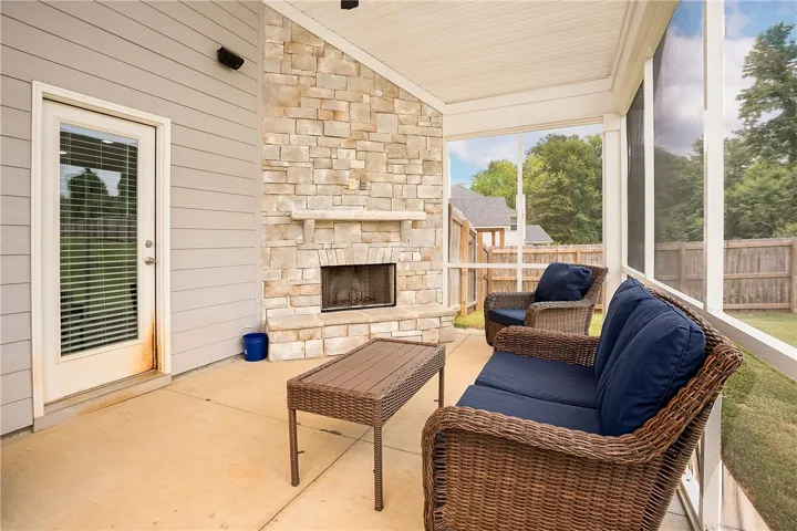 A screened patio with a cozy stone fireplace, perfect for tranquil outdoor relaxation.