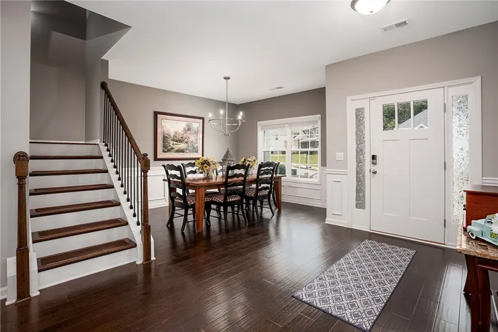 Rich hardwood floors welcome you into this inviting home's spacious entry and dining area.