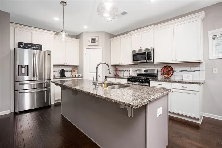 A pristine culinary space awaits, featuring rich wood flooring and brilliant lighting.