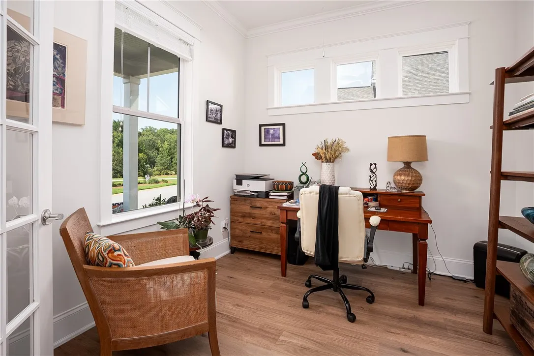 Well-lit office space with durable hardwood flooring and large windows overlooking the verdant neighborhood.