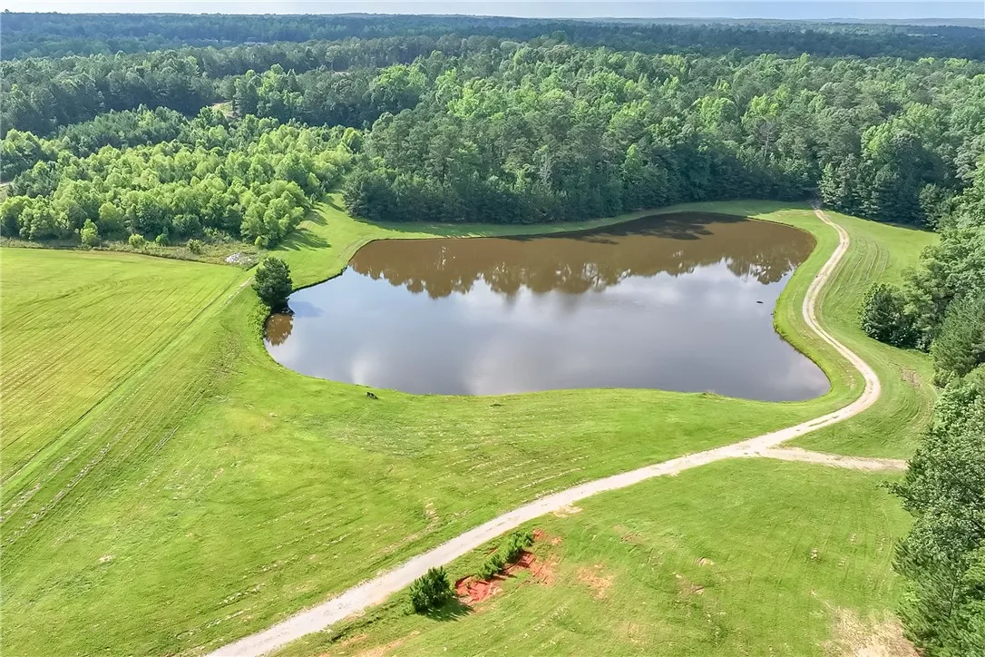 Vast green meadows and a tranquil pond offer serene rural living.
