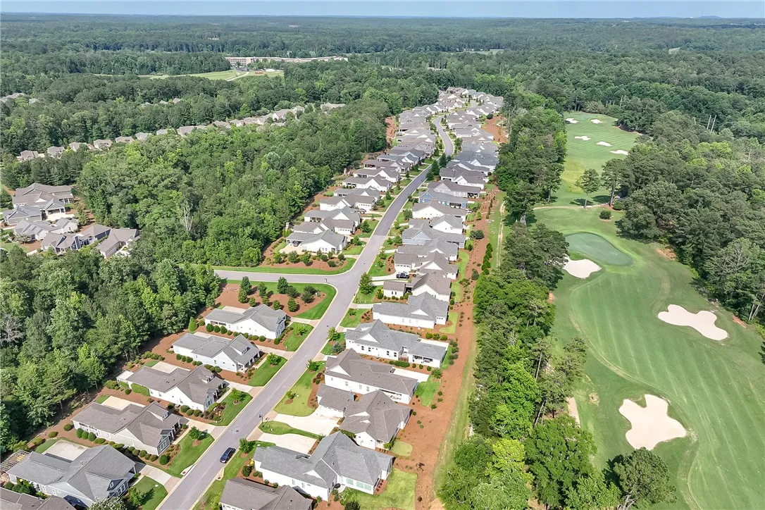 An aerial panorama reveals a residential community nestled beside a meticulously maintained golf course.