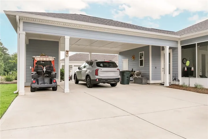 A well-maintained carport offers ample sheltered parking and direct home access.