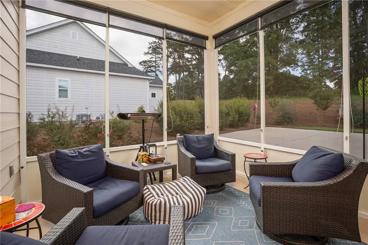 An inviting screened porch offers serene outdoor relaxation with views of the surrounding greenery.
