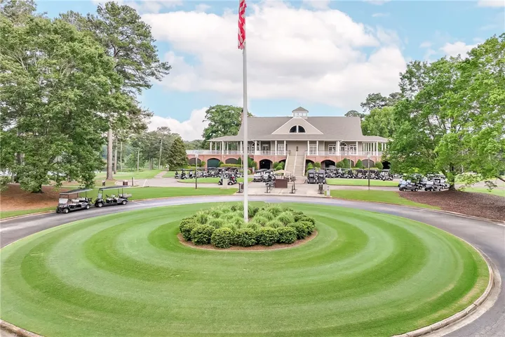 A grand clubhouse overlooks an immaculately maintained golf course, offering prime recreation and leisure.