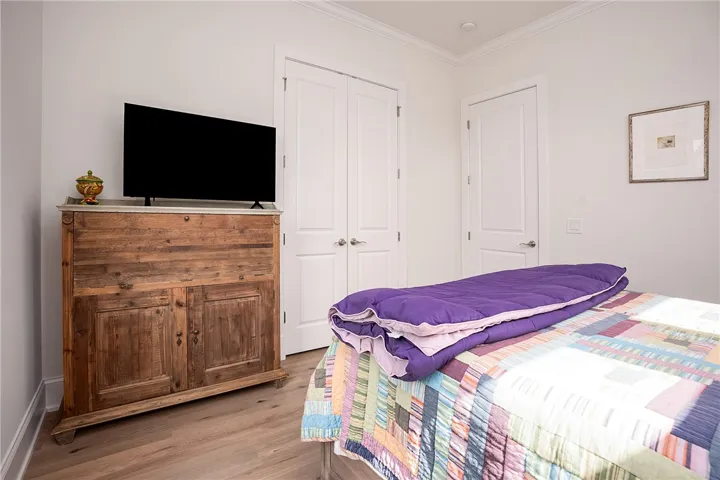 Hardwood-style flooring extends through this sleeping area, complemented by crisp white trim and doors.