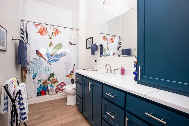 A well-lit bathroom showcases a wide vanity with ample storage and a contemporary shower area.
