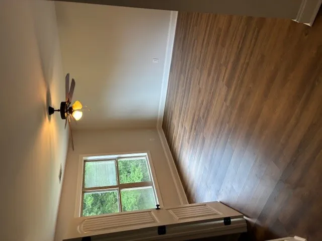 Natural light illuminates rich hardwood flooring in this versatile living area.