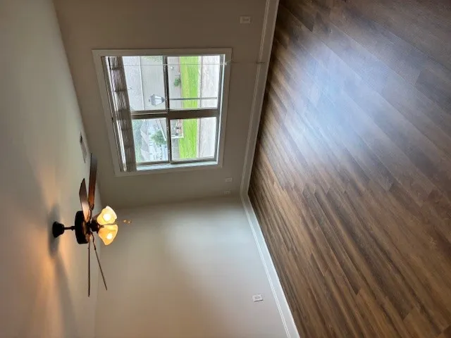 Hardwood-style flooring and a ceiling fan provide both character and comfort in this open living area.