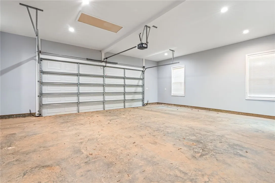 A spacious, pristine garage ready for vehicles or storage, illuminated by recessed lighting.