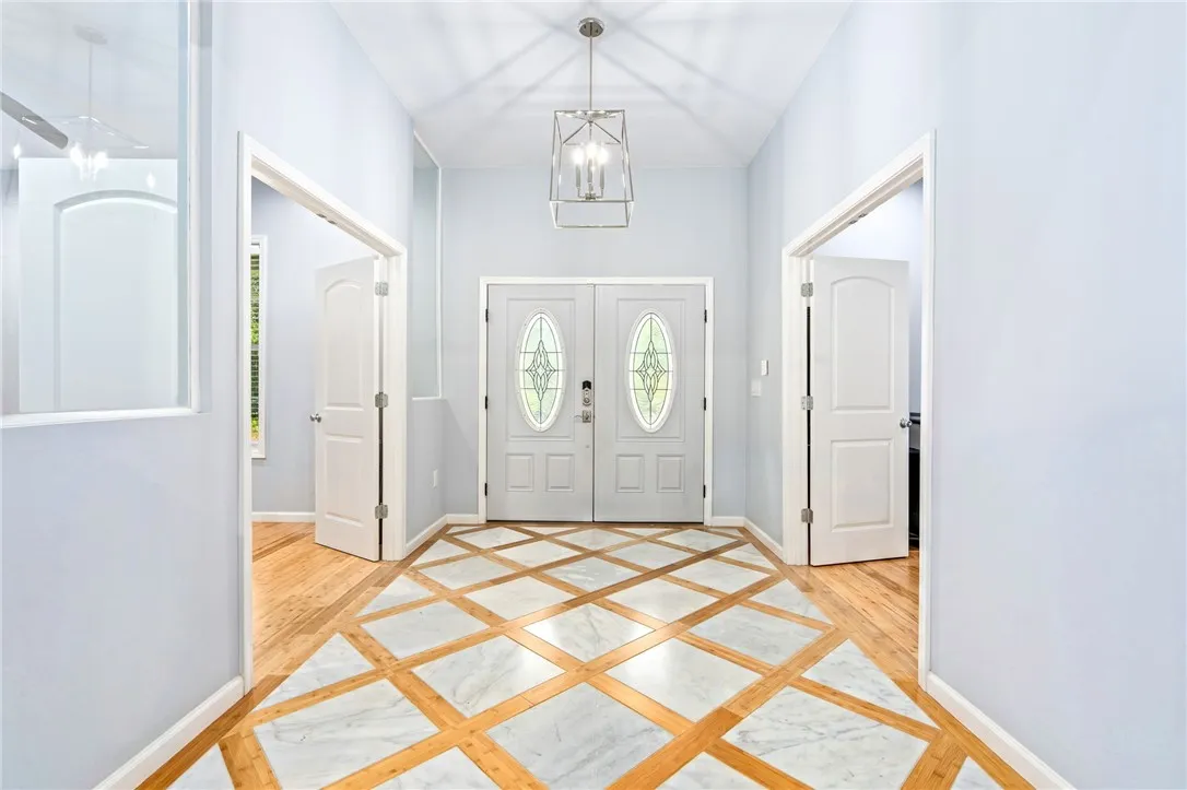 A grand entrance welcomes all with a distinctive inlaid tile and hardwood flooring pattern.
