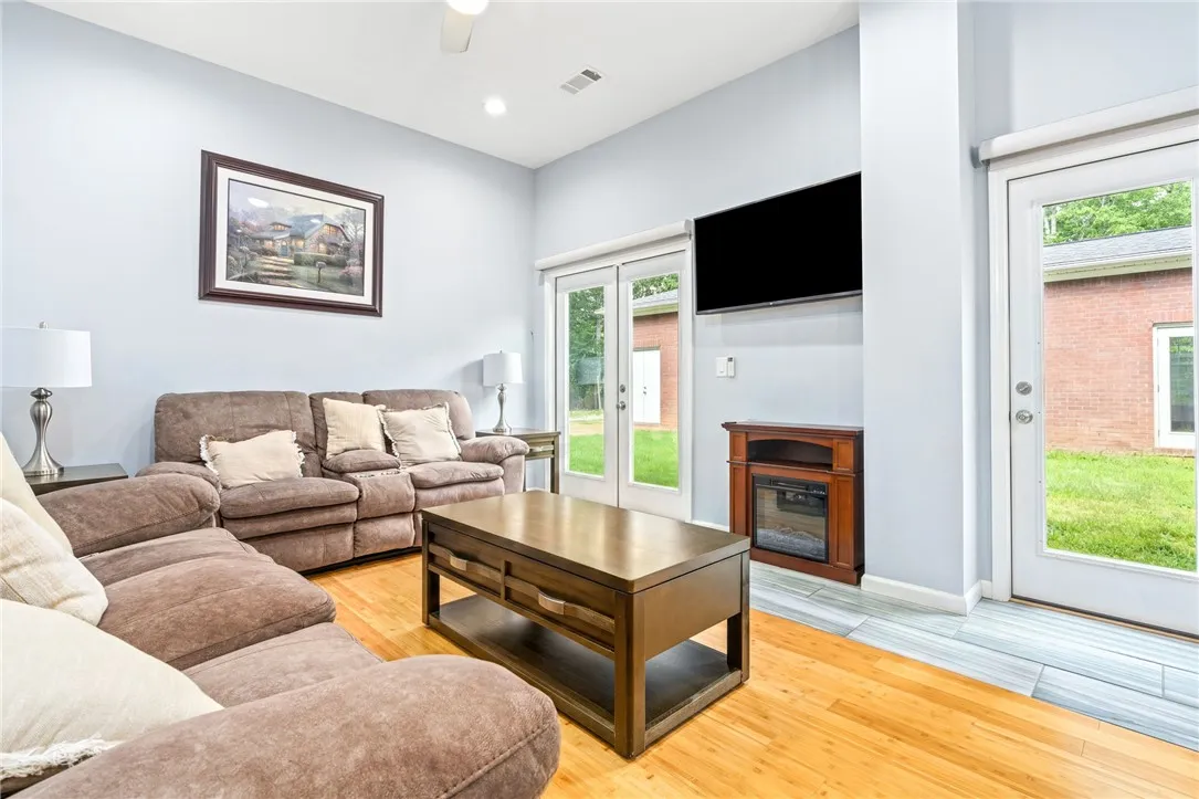 Hardwood floors and soaring ceilings define this inviting family room, opening onto a private yard.