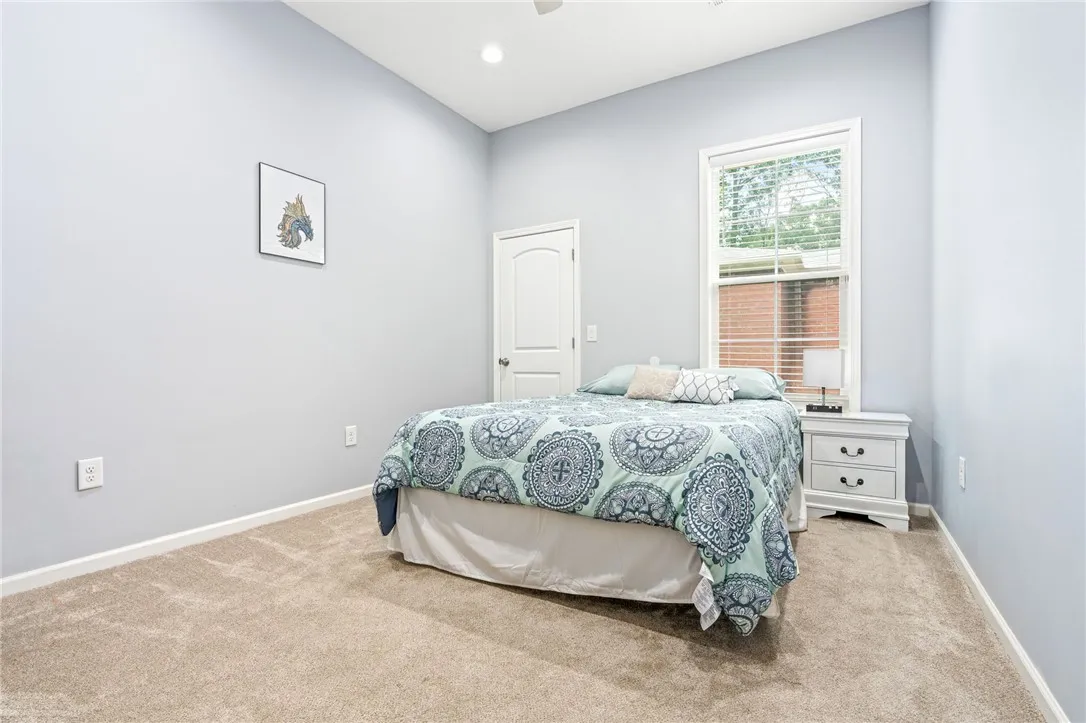 Comfortable bedroom with plush carpeting and abundant natural light from a large window.
