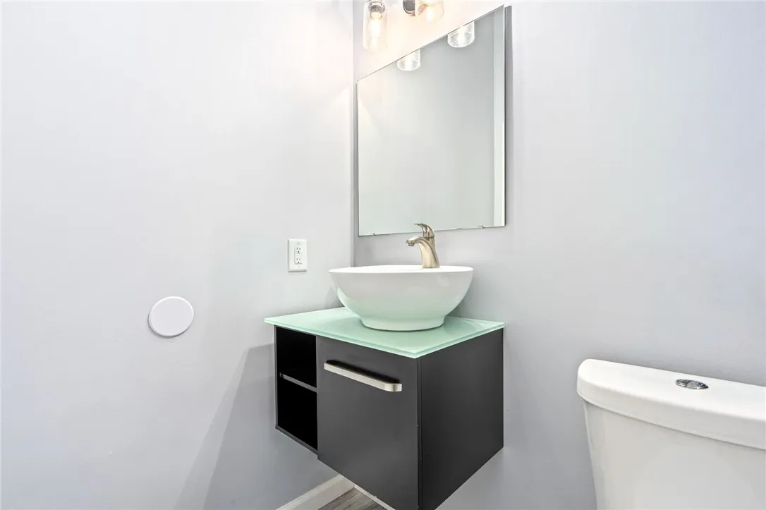 A sleek wall-mounted vanity with a vessel sink anchors this pristine bathroom.