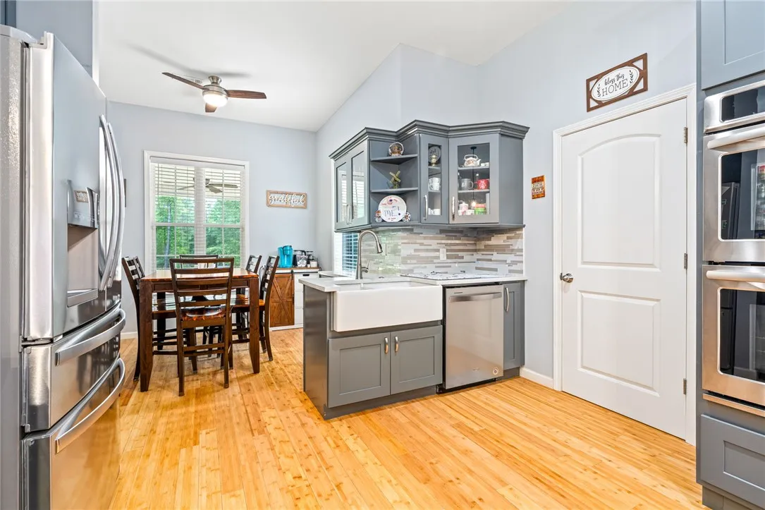 A cheerful kitchen featuring rich hardwood flooring and sleek stainless steel appliances.