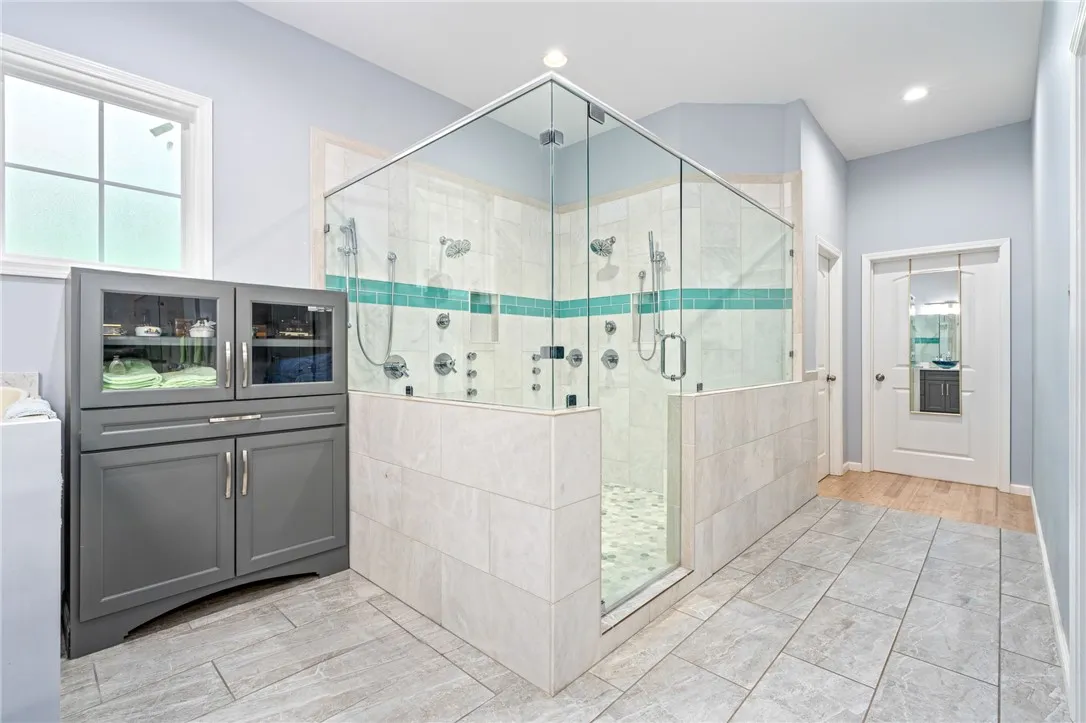 Indulge in a luxurious primary bathroom featuring a spacious walk-in shower with dual shower heads.