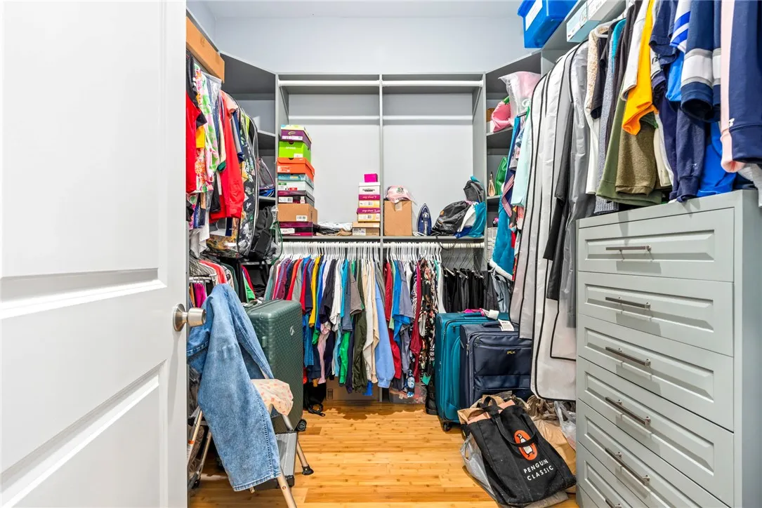 Custom shelving and hanging rods provide generous storage for a curated wardrobe.