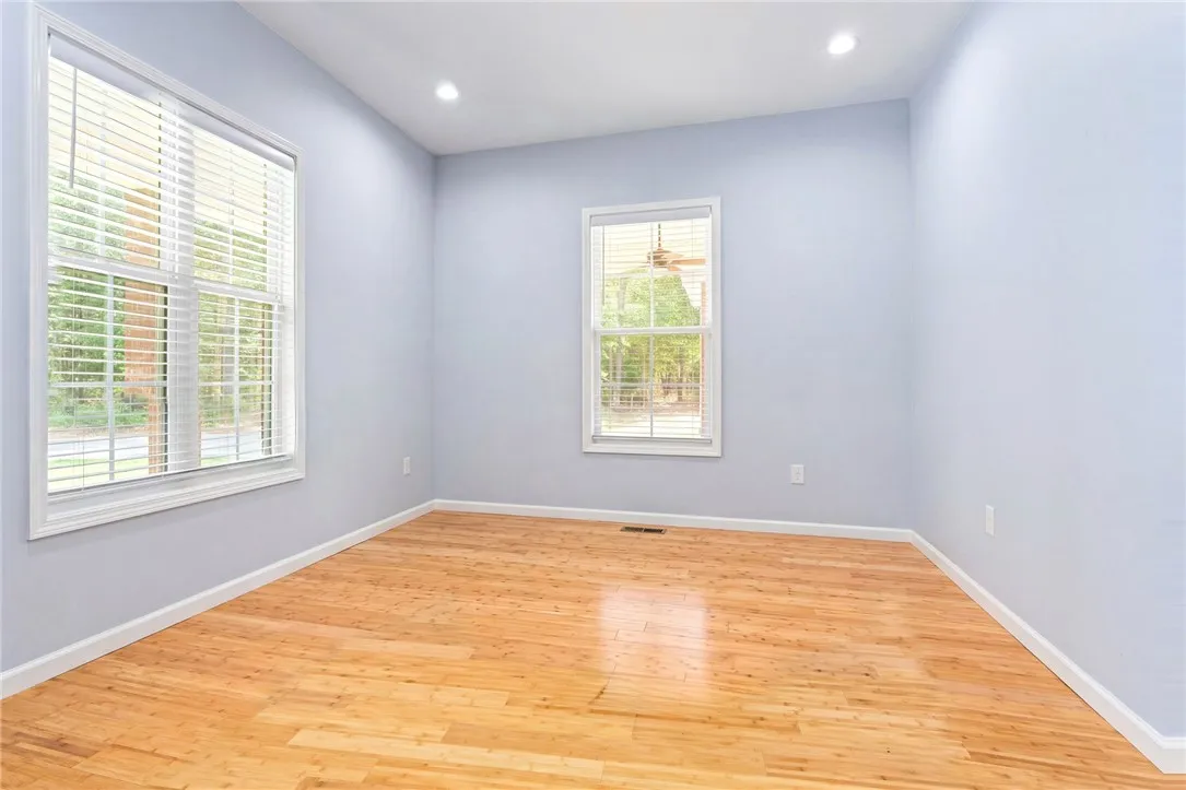 Blonde hardwood floors and ample natural light define this inviting, empty room.