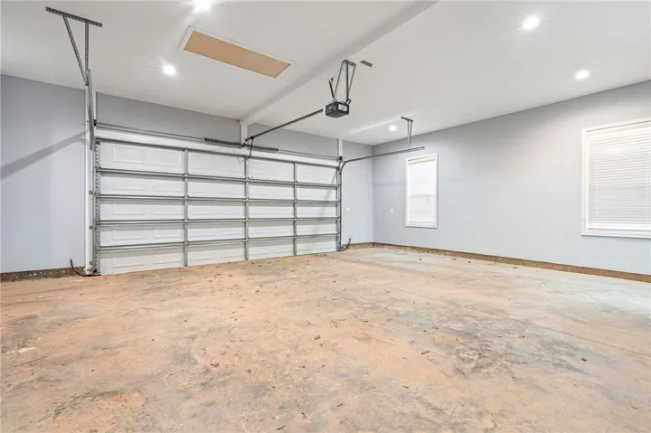 A spacious, pristine garage ready for vehicles or storage, illuminated by recessed lighting.