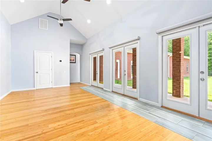 Vaulted ceilings elevate this adaptable room, offering seamless access to the outdoors through multiple French doors.
