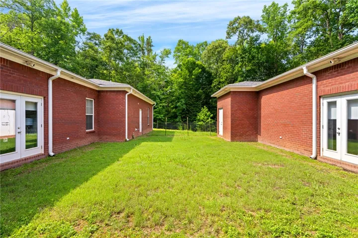 A verdant backyard retreat offering privacy with brick structures and mature trees.
