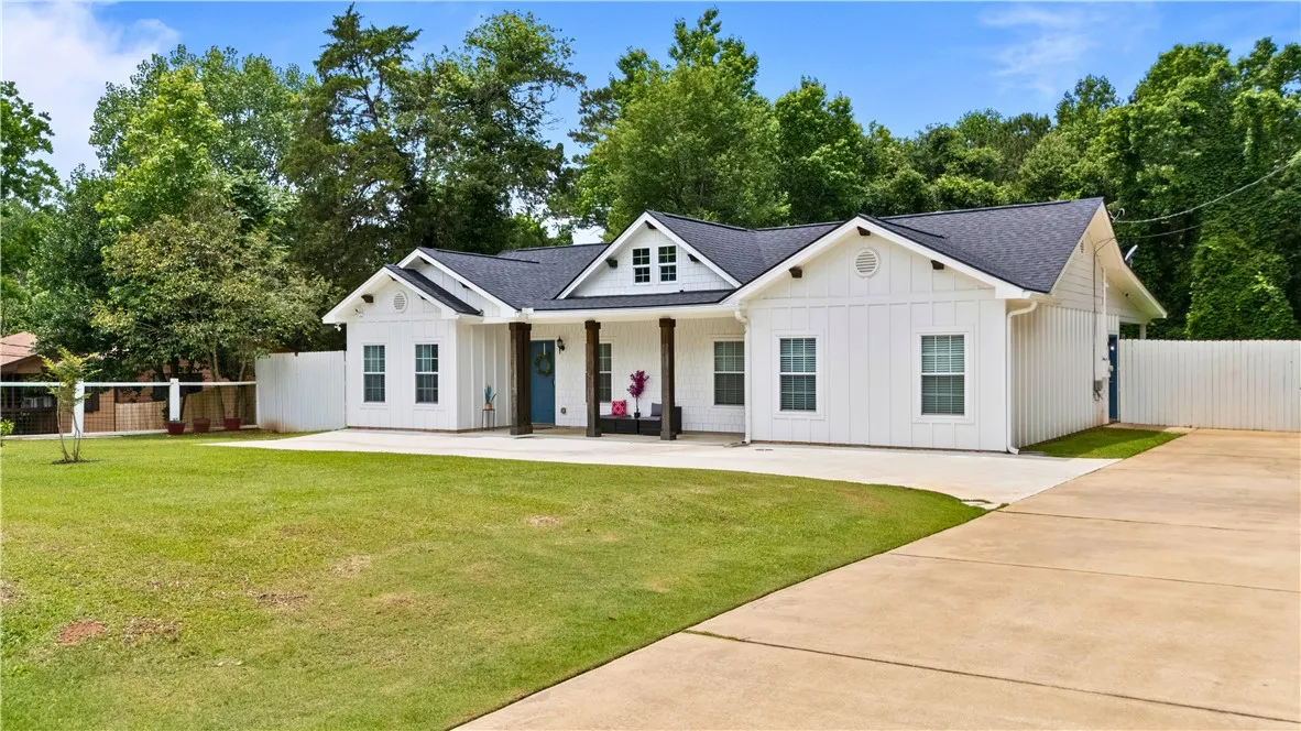 A classic facade with a welcoming covered front porch and expansive green lawn.
