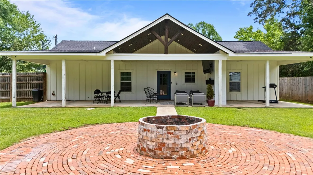 A spacious backyard patio, brick fire pit, and ample green space define outdoor living at this residence.