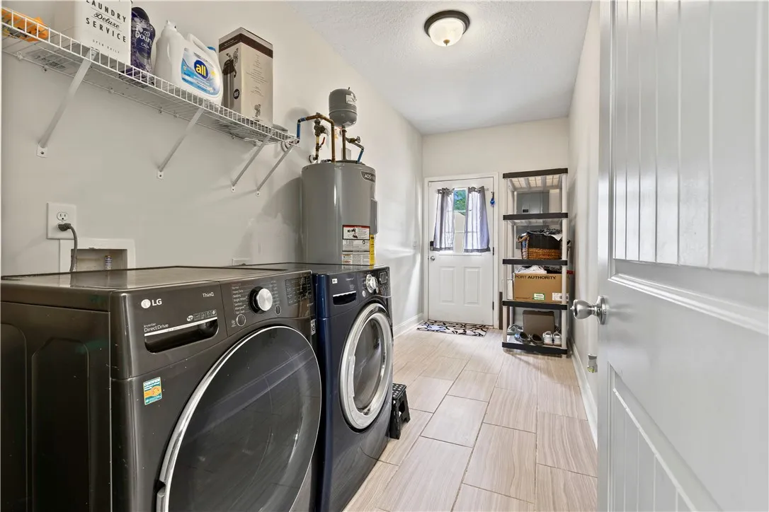 Functional laundry room offers abundant shelving and tiled flooring, simplifying household tasks.