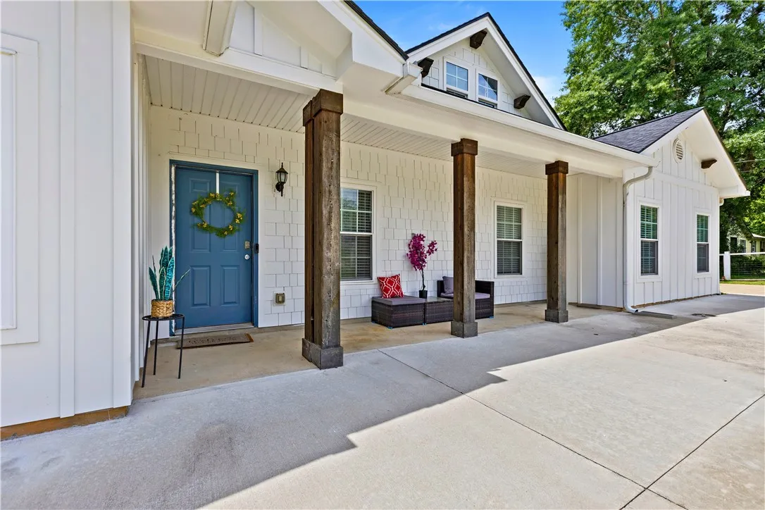 A welcoming covered porch with rustic wooden columns beckons guests to this charming residence.