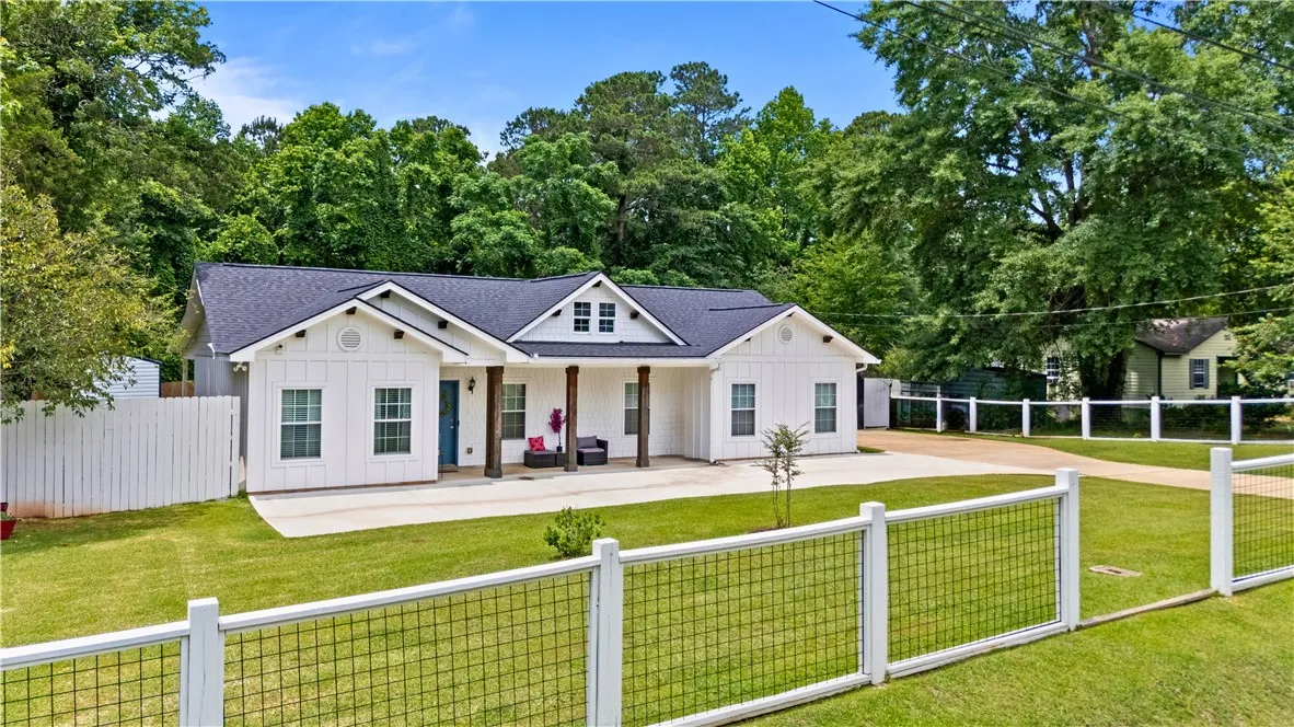 White siding and dark roofline adorn this inviting modern farmhouse.