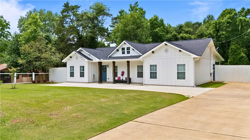 A classic facade with a welcoming covered front porch and expansive green lawn.