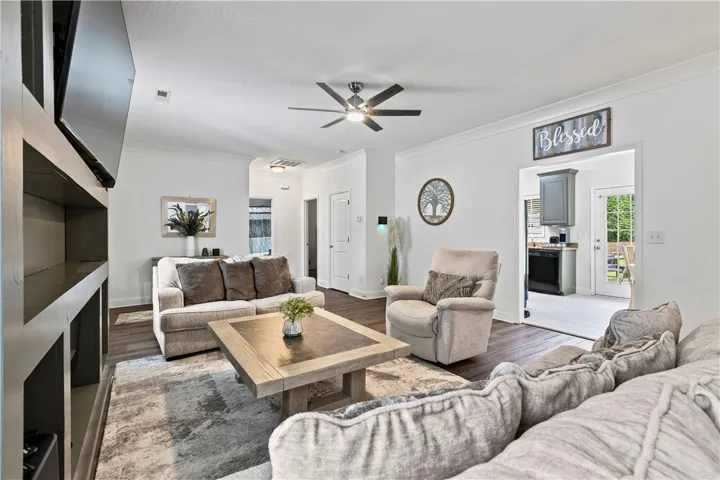 A comfortable living area with rich hardwood flooring and a stylish ceiling fan, perfect for relaxation.