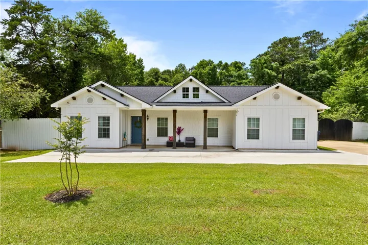 A classic white facade with a welcoming blue door and inviting covered porch.