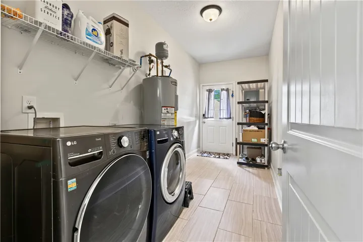 Functional laundry room offers abundant shelving and tiled flooring, simplifying household tasks.