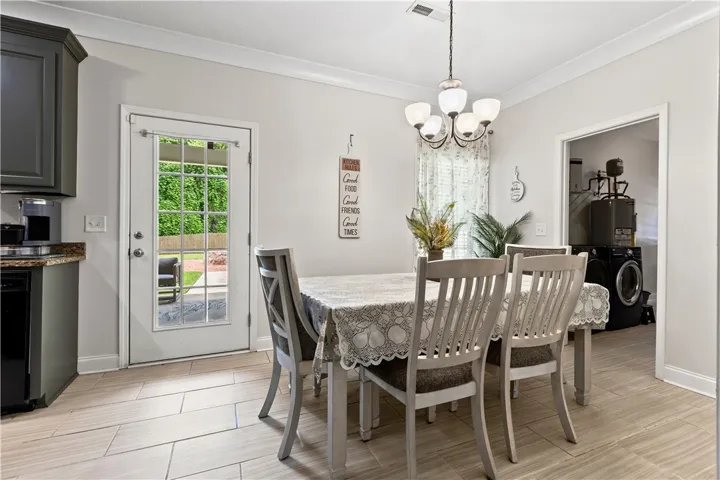 A well-lit dining area features a large windowed door leading to the yard, with convenient access to the laundry room.