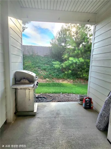 A tranquil covered patio offers views of the verdant private yard with a sturdy privacy fence.