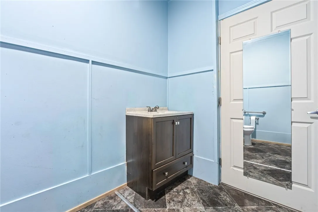 A compact vanity with sleek dark cabinetry provides essential functionality within this well-maintained bathroom.