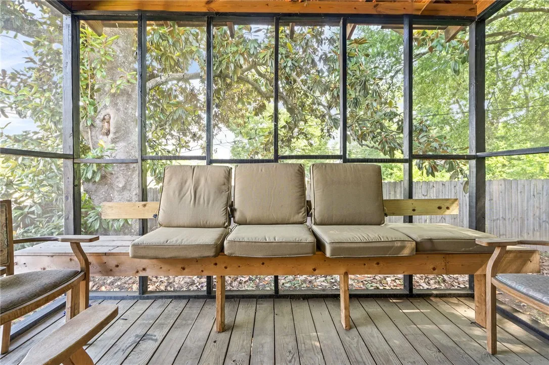 Enjoy the peaceful surroundings from this inviting screened porch, ideal for relaxation.
